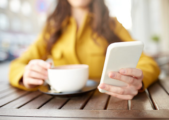 Image showing close up of woman texting on smartphone at cafe