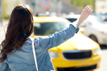 Image showing young woman or girl catching taxi on city street