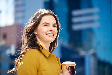 Image showing happy young woman drinking coffee on city street