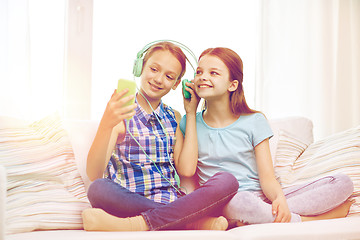 Image showing happy girls with smartphone and headphones