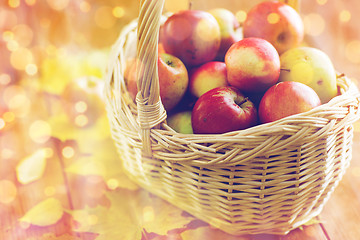 Image showing close up of basket with apples on wooden table