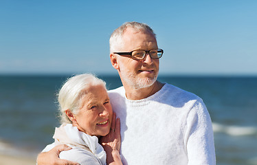 Image showing happy senior couple hugging on summer beach