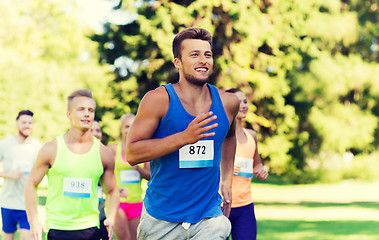 Image showing happy young sportsmen racing wit badge numbers