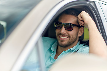 Image showing happy smiling man in sunglasses driving car