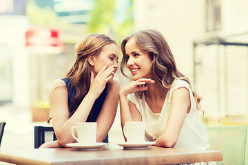 Image showing young women drinking coffee and talking at cafe