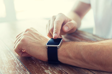 Image showing close up of male hands setting smart watch