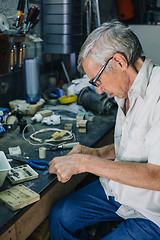 Image showing Senior engineer working in garage