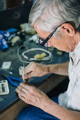 Image showing Senior engineer working in garage