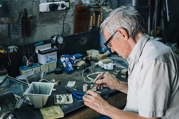 Image showing Senior engineer working in garage