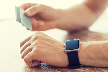 Image showing close up of hands with smart watch and credit card