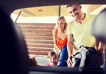 Image showing happy family packing things to car at home parking