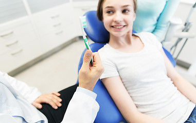 Image showing close up of dentist hand with toothbrush and girl