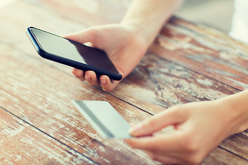 Image showing close up of hands with smart phone and credit card