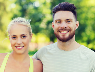 Image showing happy friends or sportsmen couple hugging outdoors