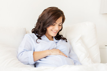 Image showing happy pregnant woman lying on bed at home