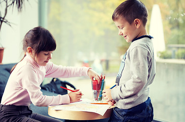 Image showing happy little girl and boy drawing at home