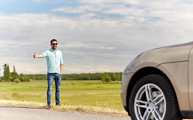 Image showing man hitchhiking and stopping car at countryside