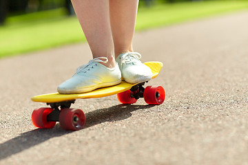 Image showing close up of female feet riding short skateboard