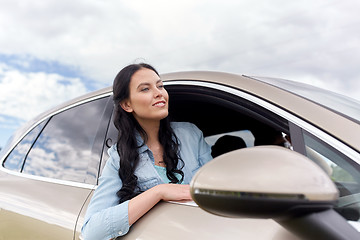 Image showing happy young woman driving in car