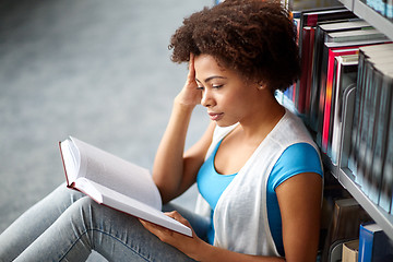Image showing african student girl reading book at library