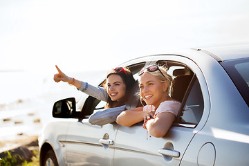 Image showing happy teenage girls or women in car at seaside