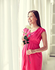 Image showing happy pregnant woman with rose flower at home