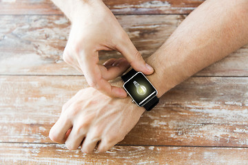 Image showing close up of hands with light bulb on smart watch