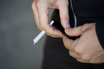 Image showing close up of addict hands with marijuana joint