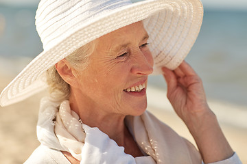 Image showing happy senior woman in sun hat on summer beach