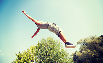 Image showing sporty young man jumping in summer park