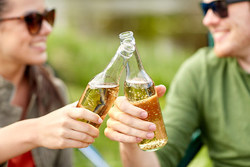 Image showing close up of happy couple clinking drinks outdoors