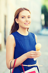 Image showing woman with shopping bags and ice cream in city