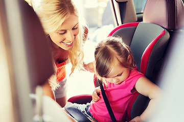 Image showing happy mother fastening child with car seat belt