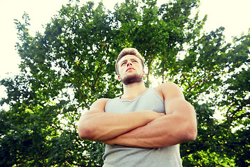 Image showing sporty young man with crossed arms at summer park