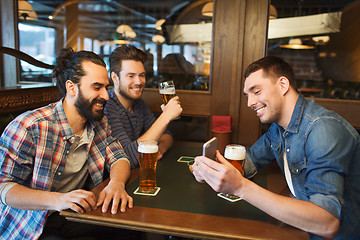 Image showing male friends with smartphone drinking beer at bar