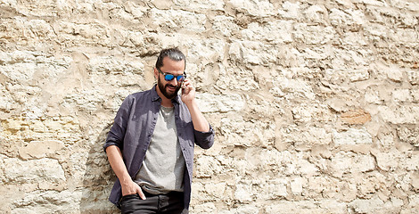 Image showing smiling man with smartphone calling on city street