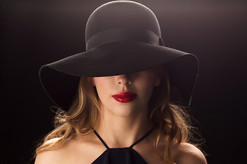 Image showing beautiful woman in black hat over dark background