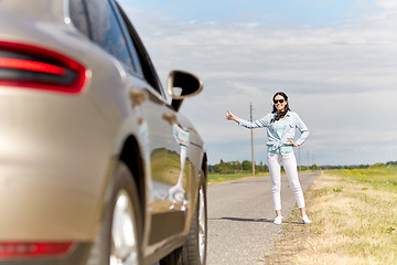 Image showing woman hitchhiking and stopping car at countryside