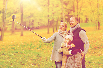 Image showing happy family with smartphone and monopod in park