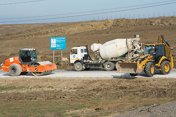 Image showing Taman, Russia - March 8, 2016: Ice Rink, cement mixer and excavator are on the road leading to the bridge being built Kerch