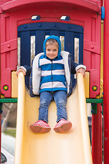 Image showing Cheerful little girl goes for a drive on a hill on a cool spring day