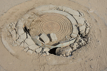 Image showing Destroyed well with cast iron lid on the dusty road