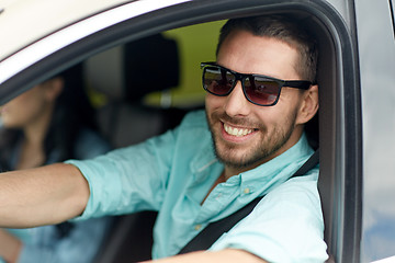 Image showing happy smiling man in sunglasses driving car