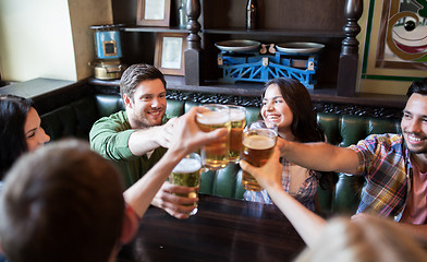 Image showing happy friends drinking beer at bar or pub