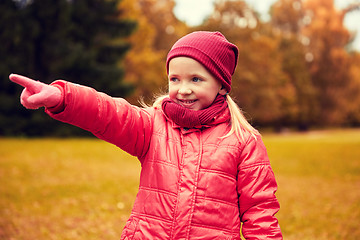Image showing happy little girl pointing finger in autumn park