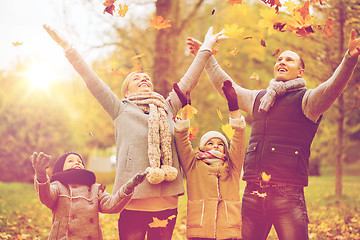 Image showing happy family playing with autumn leaves in park