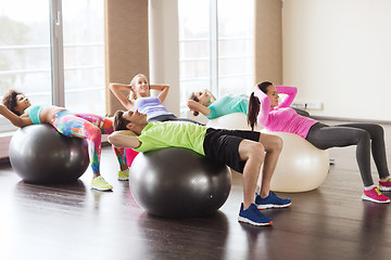 Image showing happy people flexing abdominal muscles on fitball