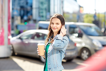 Image showing happy young woman drinking coffee on city street