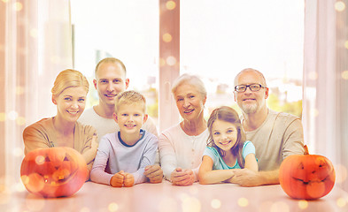 Image showing happy family sitting with pumpkins at home