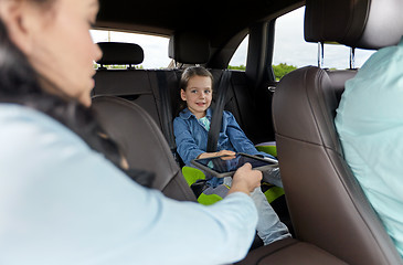 Image showing happy family with tablet pc driving in car